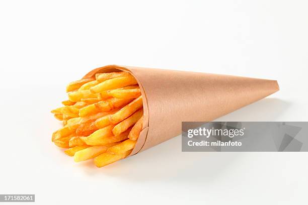 french fries in a paper cone - chips on paper stock pictures, royalty-free photos & images