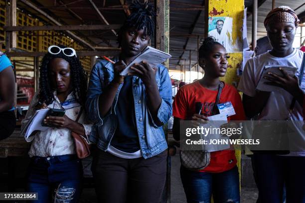 Election observers watch as voting starts in Monrovia on October 10, 2023. Liberians began voting Tuesday on whether to give football legend George...