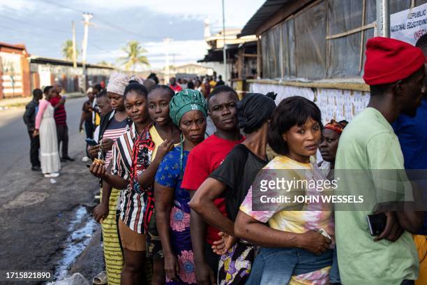 Voters wait in line at a voting station in Monrovia on October 10, 2023. Liberians began voting Tuesday on whether to give football legend George...