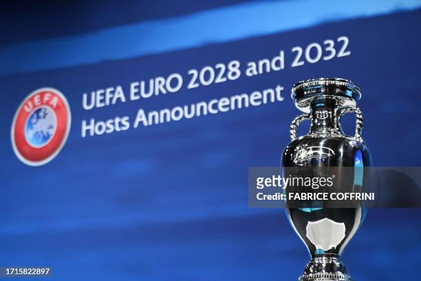 Photograph taken on October 10 shows the UEFA Euro trophy on display a few moments before the announcement of the elected countries which will host...