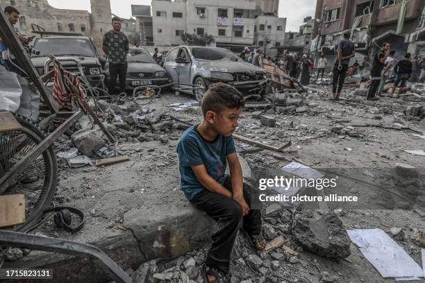 October 2023, Palestinian Territories, Khan Yunis: A Palestinian boy sits among the rubble of a destroyed building, following an Israeli air attack...