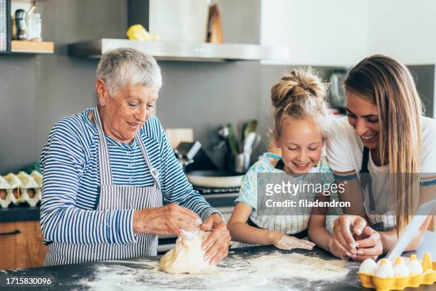 three generation women making cookies and have fun - baking bread imagens e fotografias de stock