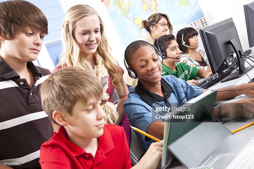 Pre-teen students in computer lab with instructor. Classroom, school, education.