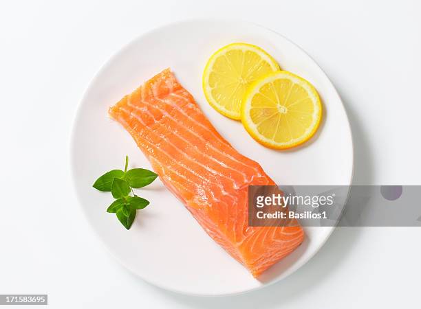 filet de saumon sur une assiette - pavé de saumon photos et images de collection