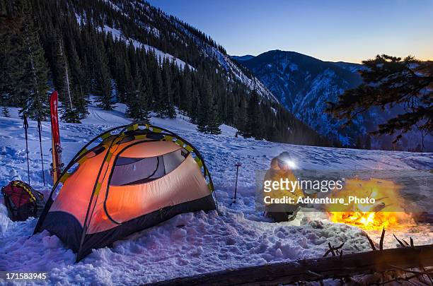 winter backcountry camp with man cooking on gas stove - beaver creek colorado stock pictures, royalty-free photos & images
