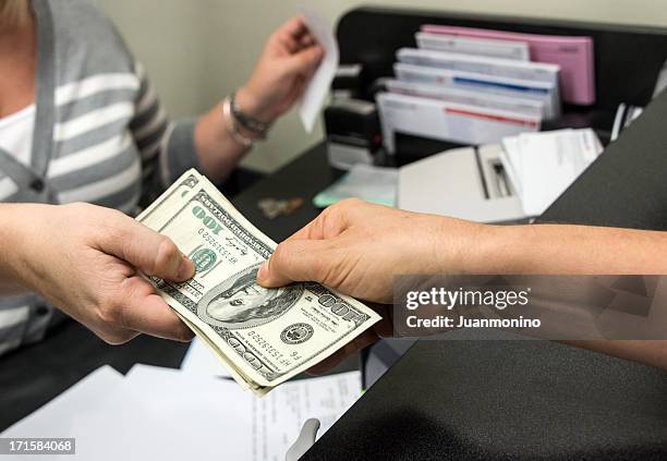 close-up image of a woman getting a cash from a bank teller - bank teller stock pictures, royalty-free photos & images