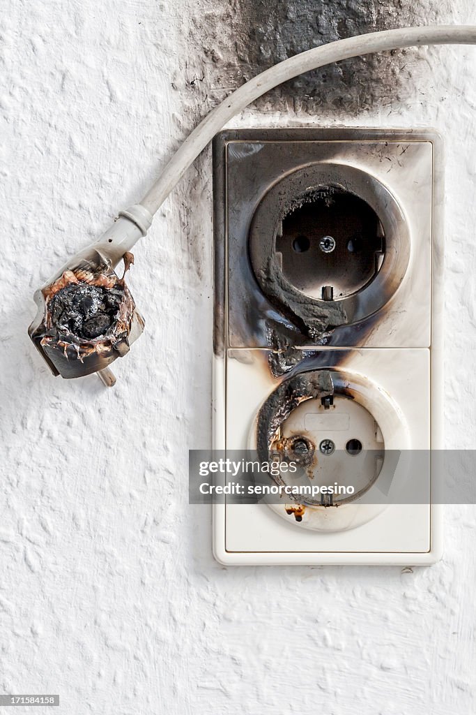 Close-up of electrical fire with the wire and wall plug