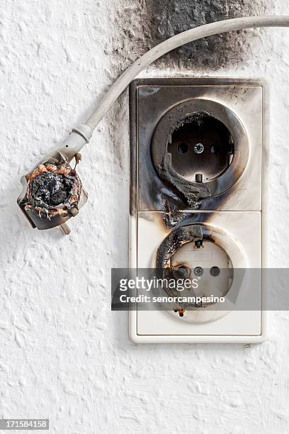 close-up of electrical fire with the wire and wall plug - eluttag bildbanksfoton och bilder