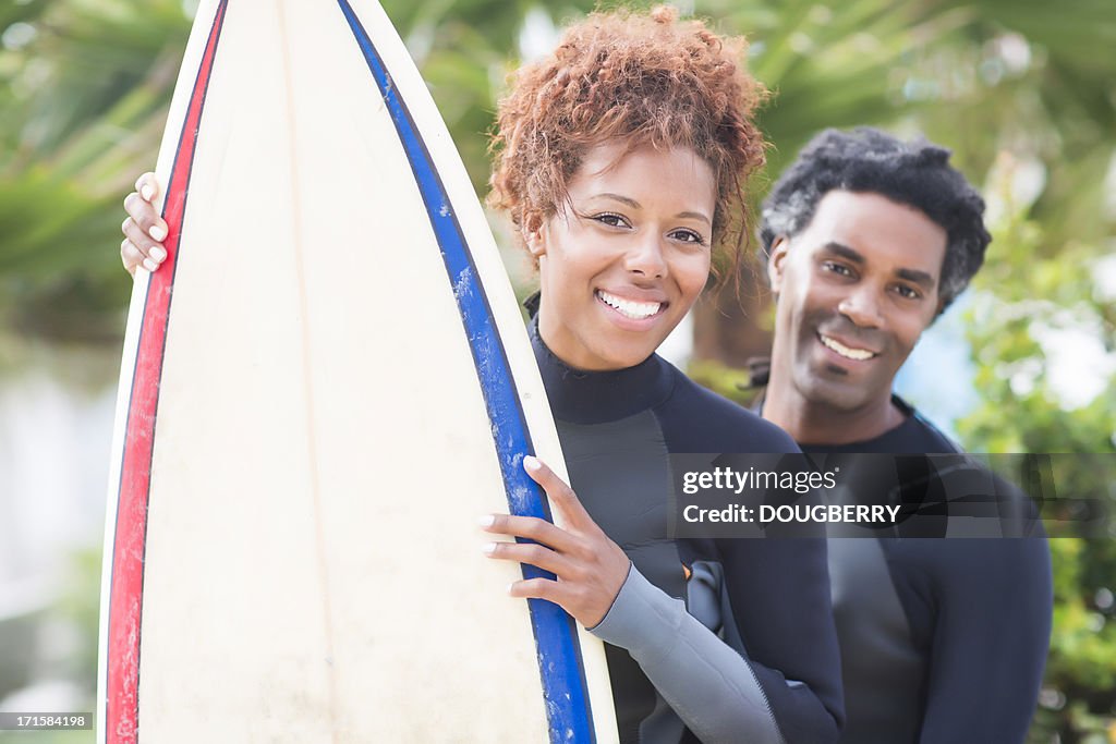 Happy couple with surfboard
