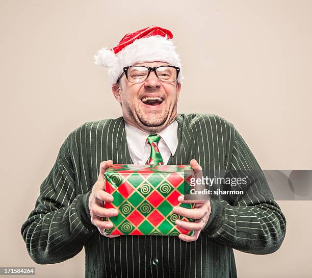 nerdy geek christmas man holding wrapped holiday gift - ugly people stock pictures, royalty-free photos & images