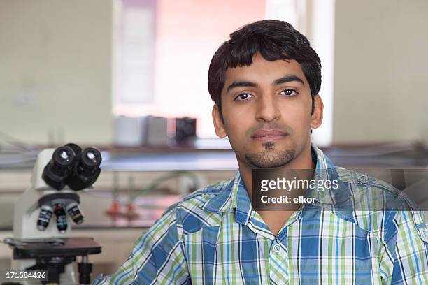 indian student with microscope in a laboratory - rajasthani youth stock pictures, royalty-free photos & images