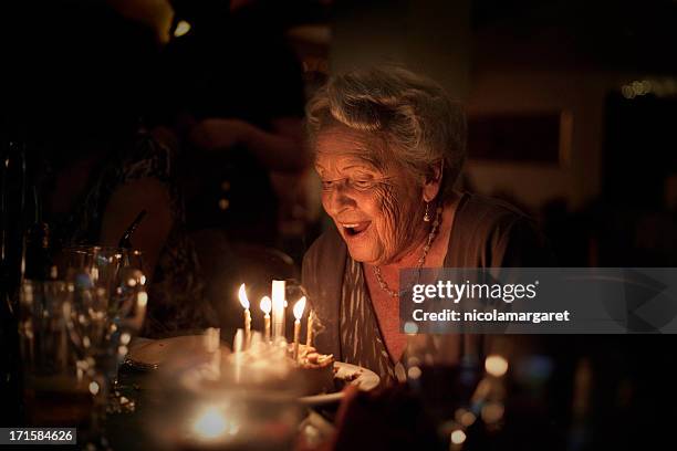 elderly lady: birthday celebration - cake candles dark stock pictures, royalty-free photos & images