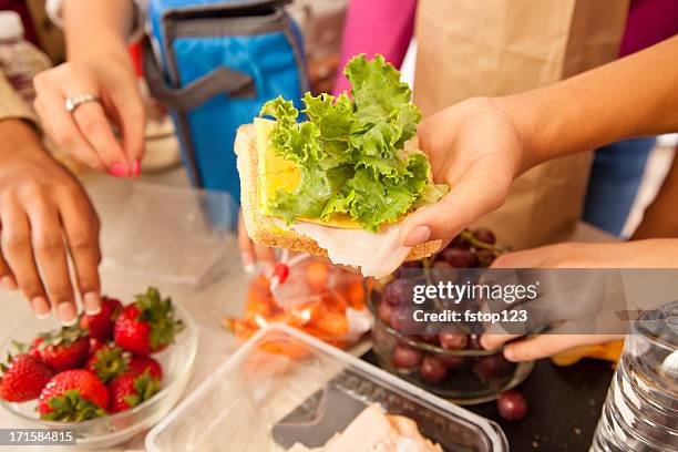 multi-ethnic group of teenagers, home kitchen making school lunches. - school lunch stock pictures, royalty-free photos & images