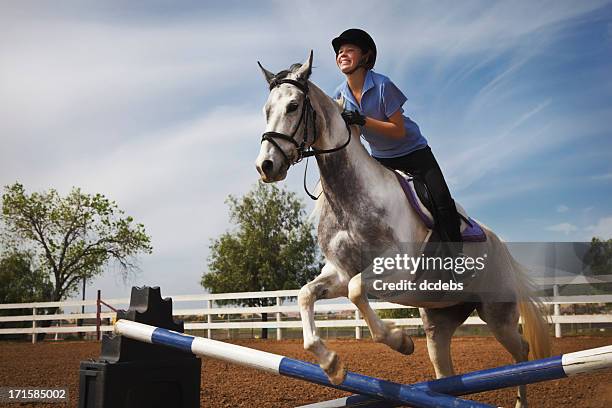 teen girl riding horse over jump - post horse stock pictures, royalty-free photos & images