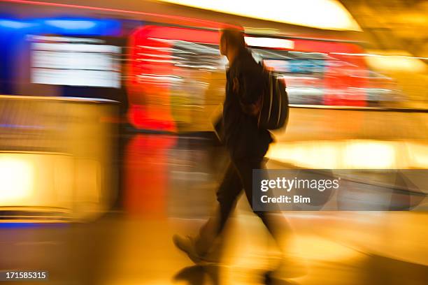 man with backpack walking past illuminated stores, motion blur - long exposure light trails stock pictures, royalty-free photos & images