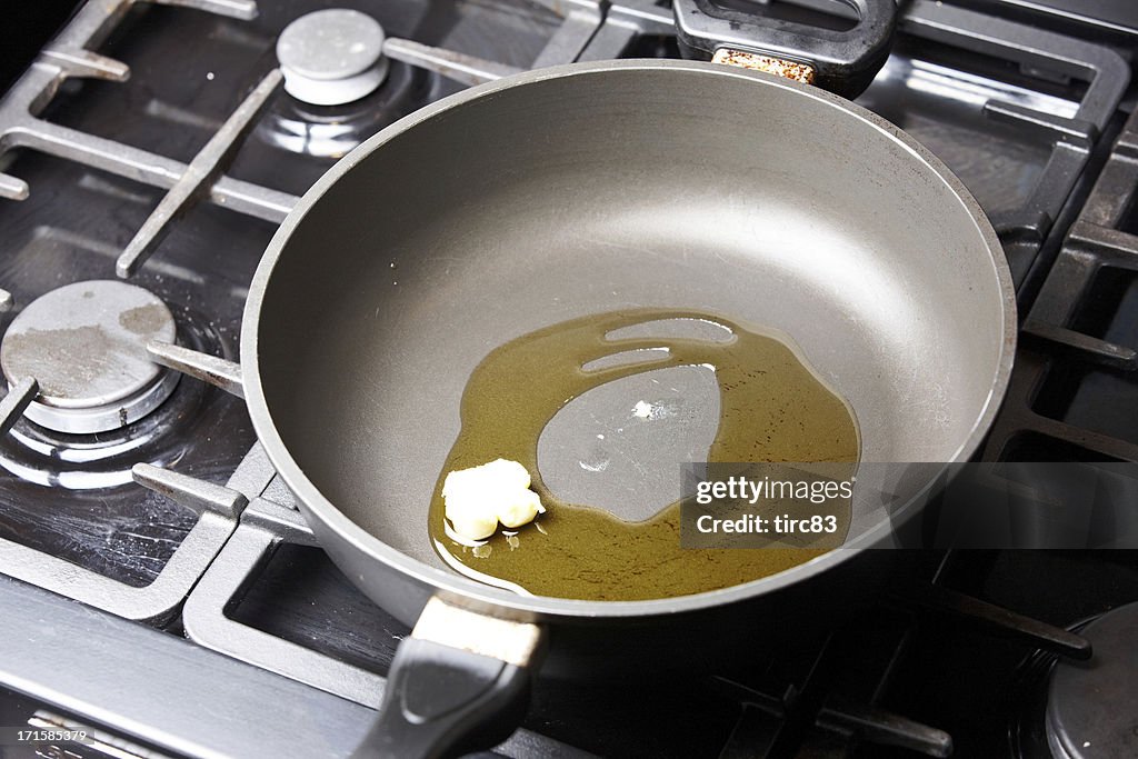 Frying pan with butter melting in olive oil