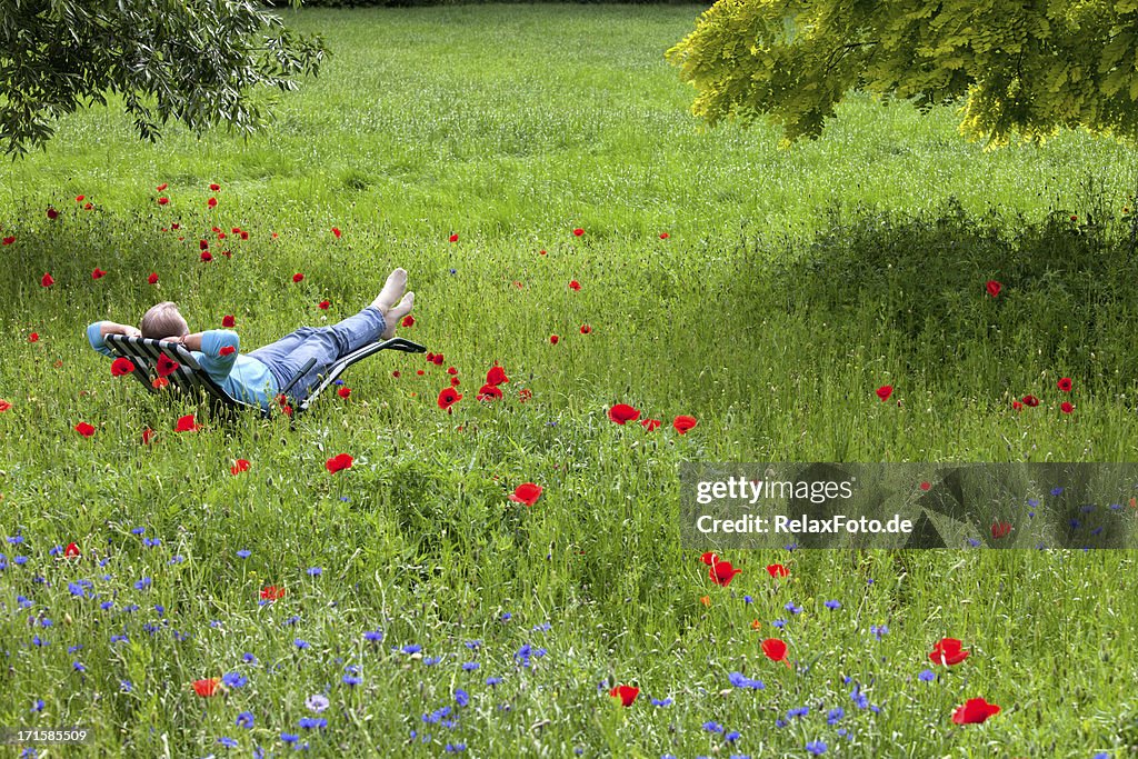 Senior man relaxing on deck chair in garden