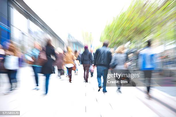 crowd of people walking down walkway past stores, blurred motion - city street blurred stockfoto's en -beelden