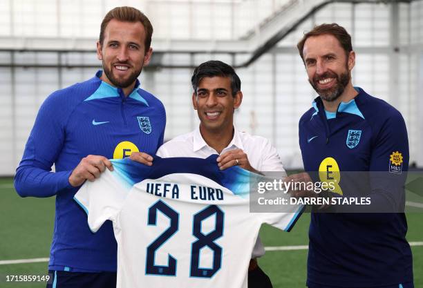 Britain's Prime Minister Rishi Sunak poses with England striker Harry Kane and England Manager Gareth Southgate during a visit to St George's Park in...