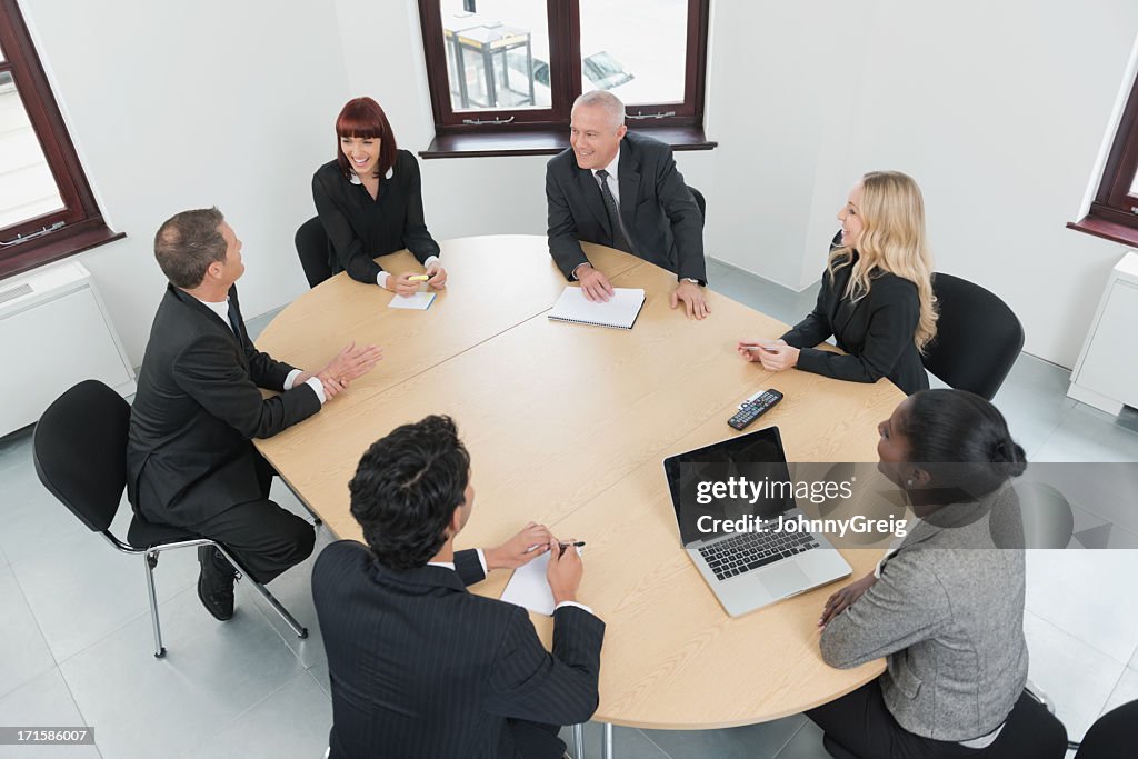 Meeting of 6 men and women in a business setting