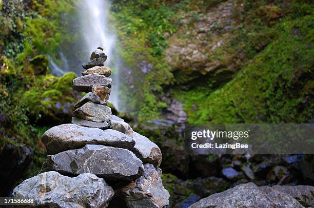 stone cairn with distant waterfall - nelson lakes national park stock pictures, royalty-free photos & images