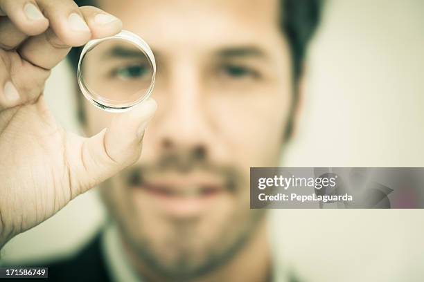businessman looking through a round lens - genomskinlig bildbanksfoton och bilder