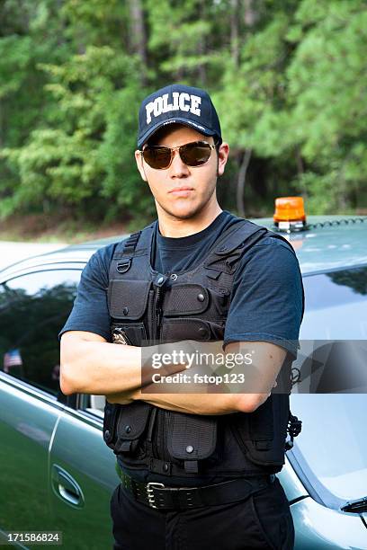 latin policeman standing beside his vehicle - police hat stock pictures, royalty-free photos & images