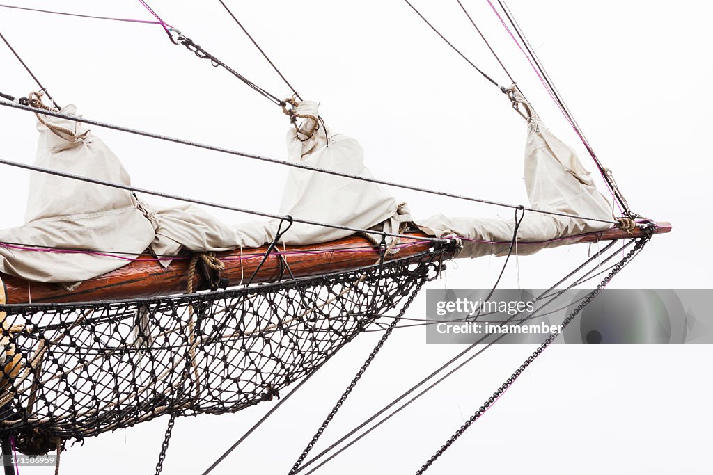 Old sailing ship bowsprit against white background, copy space