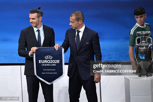 President Aleksander Ceferin and Welsh retired professional footballer, heading the delegation of UK and Ireland Gareth Bale , pose with the pennant...