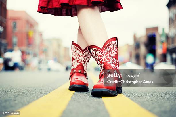 vaquera con fundas rojo en la calle - red boot fotografías e imágenes de stock