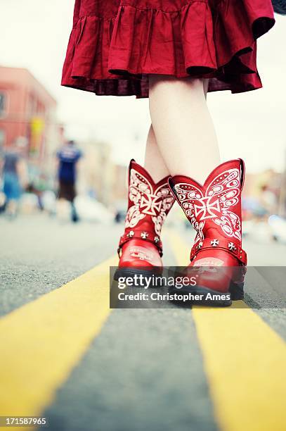 cowgirl with red boots in the road - old boots stock pictures, royalty-free photos & images