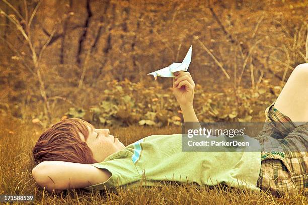 bambino felice con una gru origami pace in natura all'aperto - origami a forma di gru foto e immagini stock