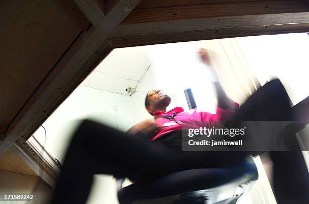 uomo d'affari arrampicata in una sedia visitando documento - zona inguinale foto e immagini stock