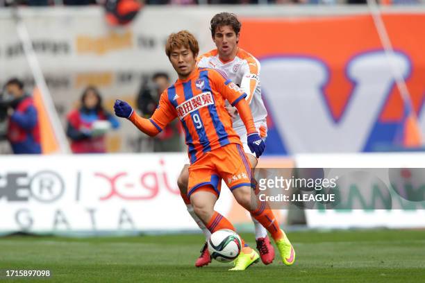 Ryohei Yamazaki of Albirex Niigata controls the ball against Dejan Jakovic of Shimizu S-Pulse during the J.League J1 first stage match between...