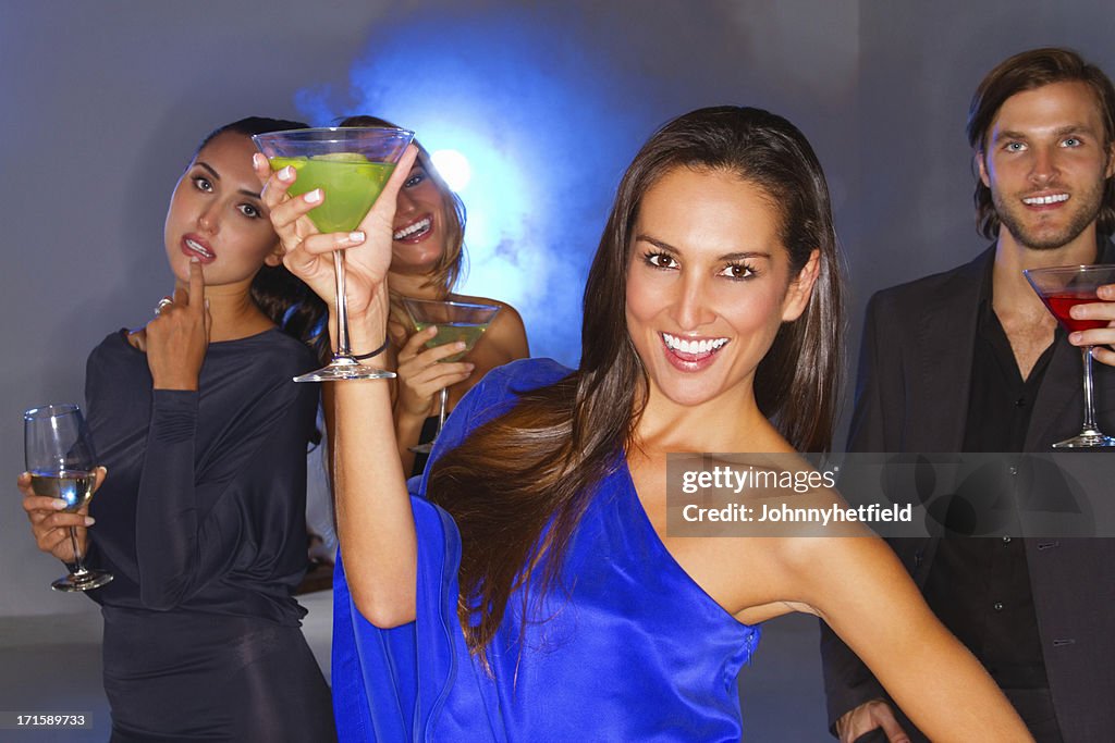 Woman Holding Cocktail Glass With Friends In Nightclub