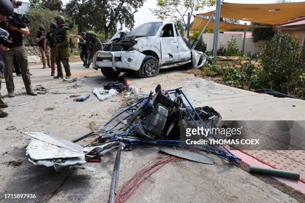 Israeli soldiers and journalists gather around a damaged powered paraglider allegedly used by Palestinian militants in Kfar Aza, south of Israel...
