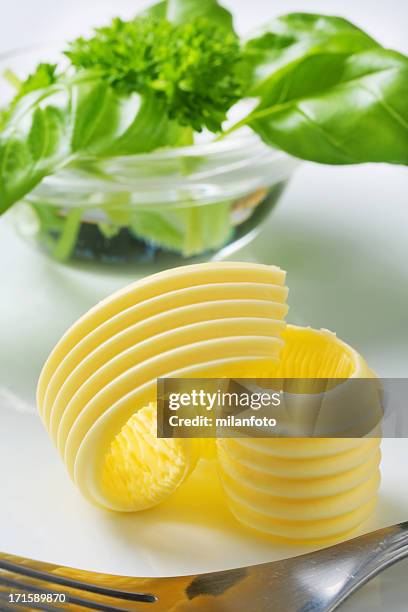 butter curl and bowl of herbs - butter curl stock pictures, royalty-free photos & images