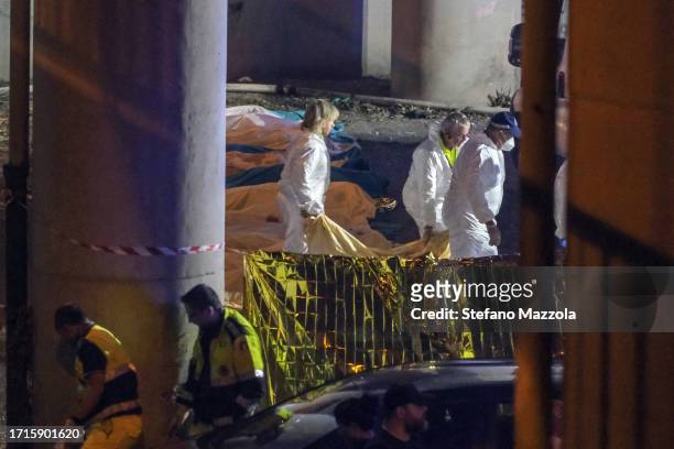 Emergency crew members carry a victim wrapped in a sheet after a bus carrying tourists crashed near Venice on October 04, 2023 in Mestre, Italy. A...