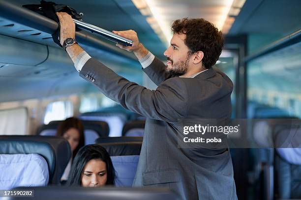 businessman  put  computer bag  on overhead luggage racks - computor bildbanksfoton och bilder