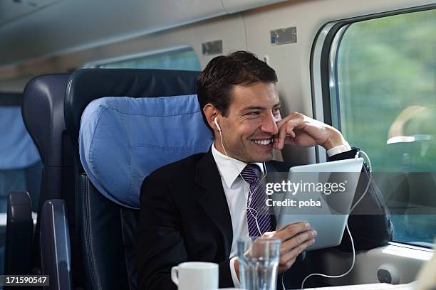bussinesman seating on a train beside window using digital tablet - next to stock pictures, royalty-free photos & images