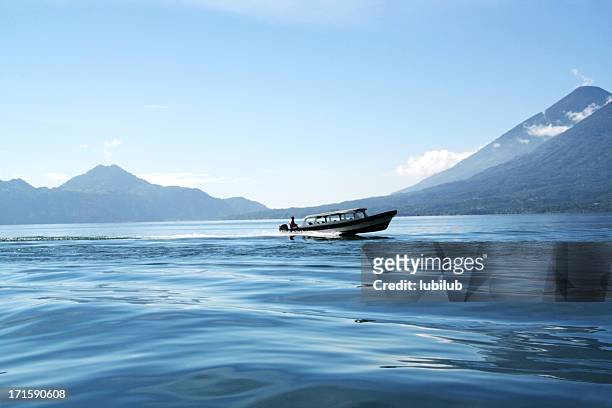 boat at full speed on lake atitlan in panajachel, guatemala - lake atitlan stock pictures, royalty-free photos & images