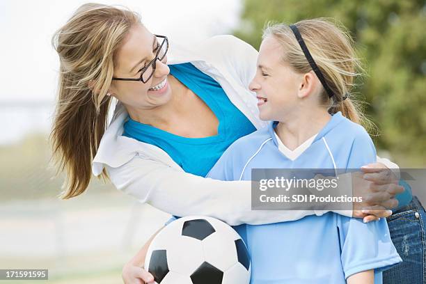 mädchen mit fußball ball begeistert lächeln mit ältere frau. - soccer mum stock-fotos und bilder