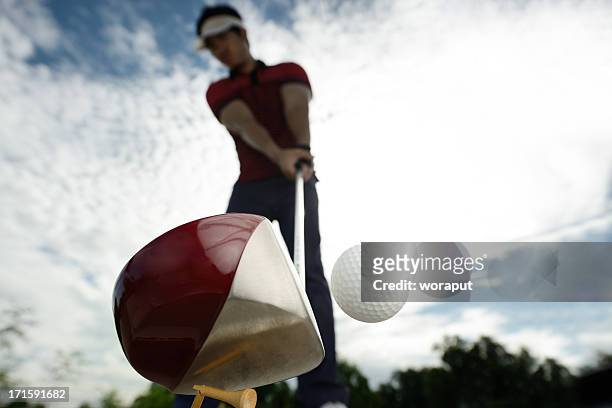 upward view of a golfer mid golf swing - golf ball stock pictures, royalty-free photos & images