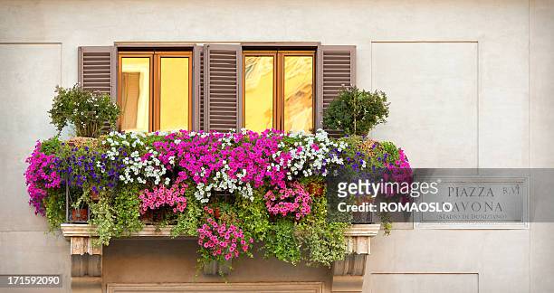 a balcony with multicolored flowers - balcony stock pictures, royalty-free photos & images