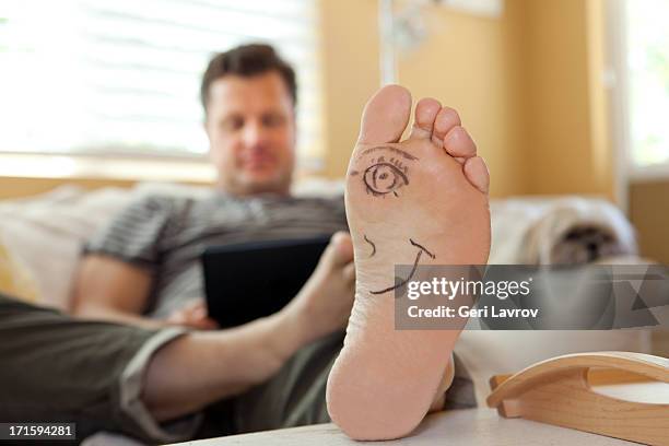 mans foot with a half a face drawn on it - male feet on face stock pictures, royalty-free photos & images