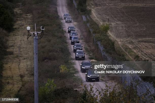 This photograph taken on October 10 shows a motorcade of Bulgarian Border police vehicles driving along the wall fence on the Bulgaria-Turkey border...