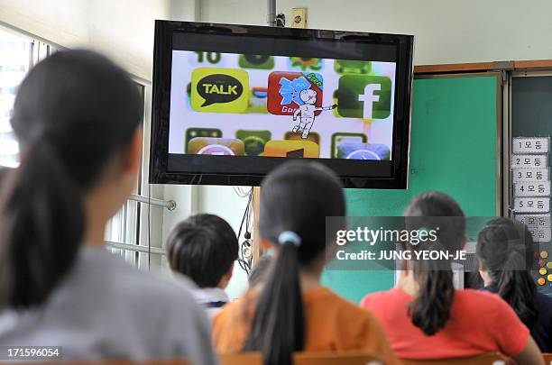 SKorea-technology-IT-addiction-health,FEATURE by JUNG Ha-Won This picture taken on June 11, 2013 shows South Korean children looking at a TV screen...