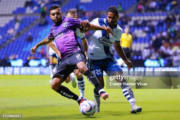 Jesus Corona of Monterrey battles for possession with Brayan Angulo of Puebla during the 11th round match between Puebla and Monterrey as part of the...