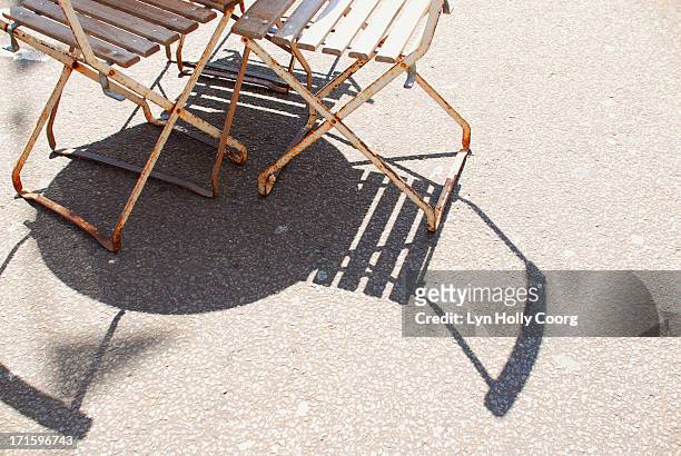 rusty chairs and table casting shadows on ground - lyn holly coorg fotografías e imágenes de stock