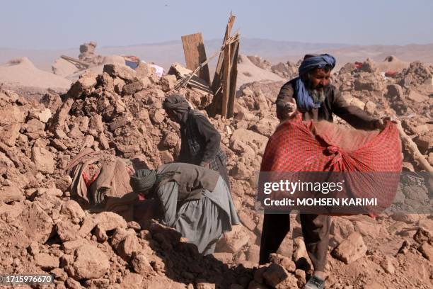 Afghan residents clear debris of damaged houses after earthquake in Nayeb Rafi village, Zendeh Jan district of Herat province on October 10, 2023....